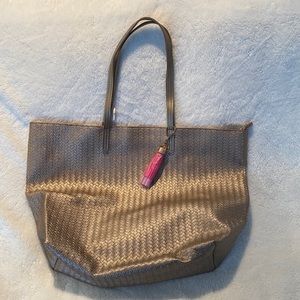 Large gold tote with a pink tassle, brand new, tassle still wrapped in plastic.